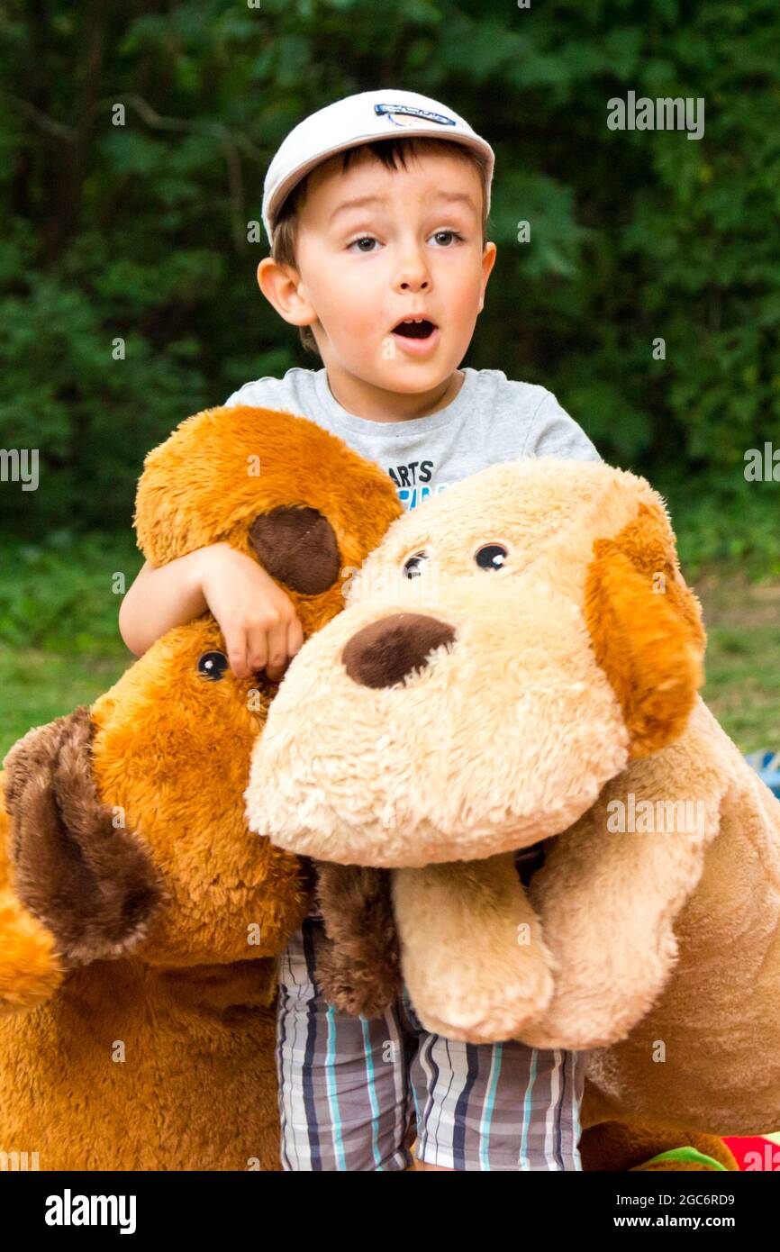 4-year-old-boy-child-with-big-plush-toy-dogs-standing-surprised-with
