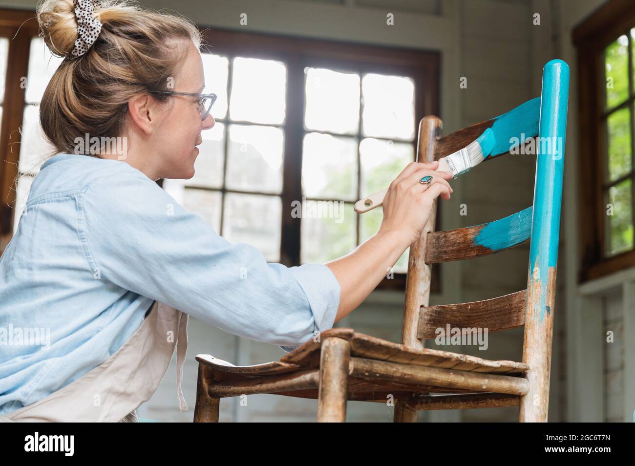 Woman painting old wooden chair Stock Photo