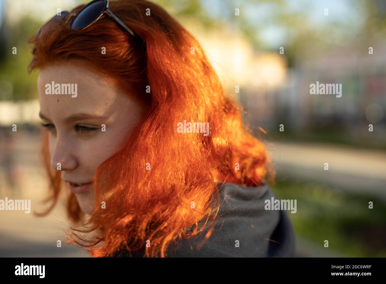 The girl has red hair. Colored hair. Summer girl on the street. Portrait of a teenager. Stock Photo