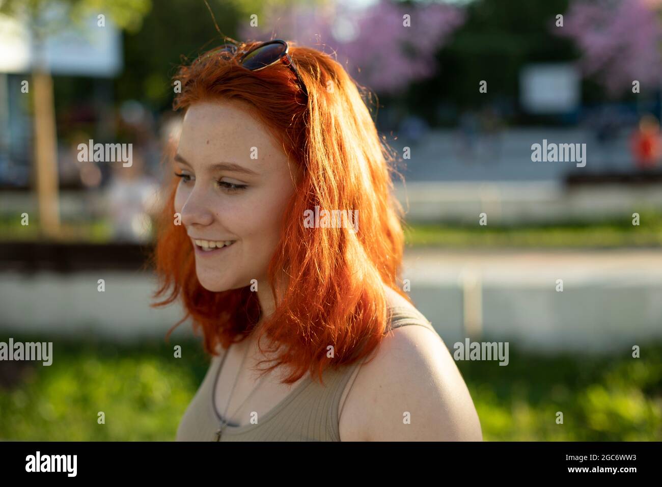 The girl has red hair. Colored hair. Summer girl on the street. Portrait of a teenager. Stock Photo