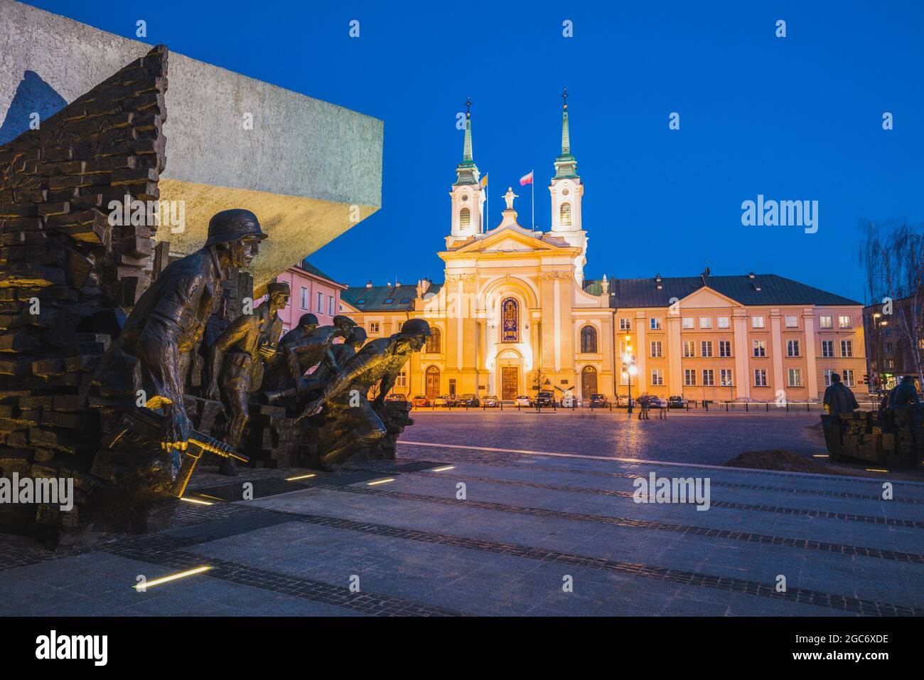 Poland, Masovia, Warsaw, Town square with World War II monument and illuminated cathedral Stock Photo