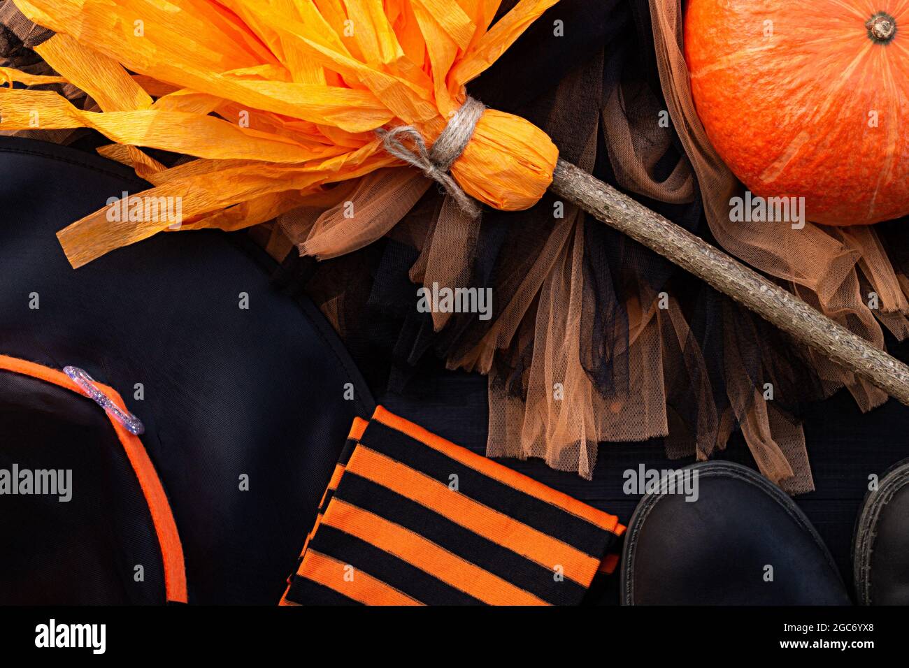 Orange and black Halloween flatlay. Witch clothes: stockings, boots, hat, broom, skirt Stock Photo