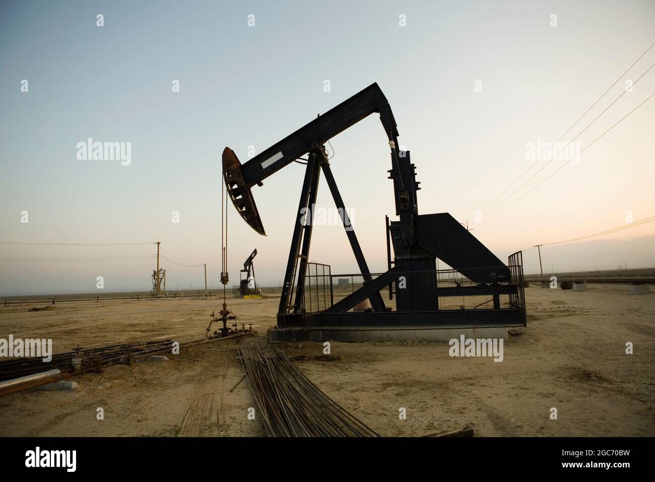 Silhouette of pump jack in oil field at sunset Stock Photo