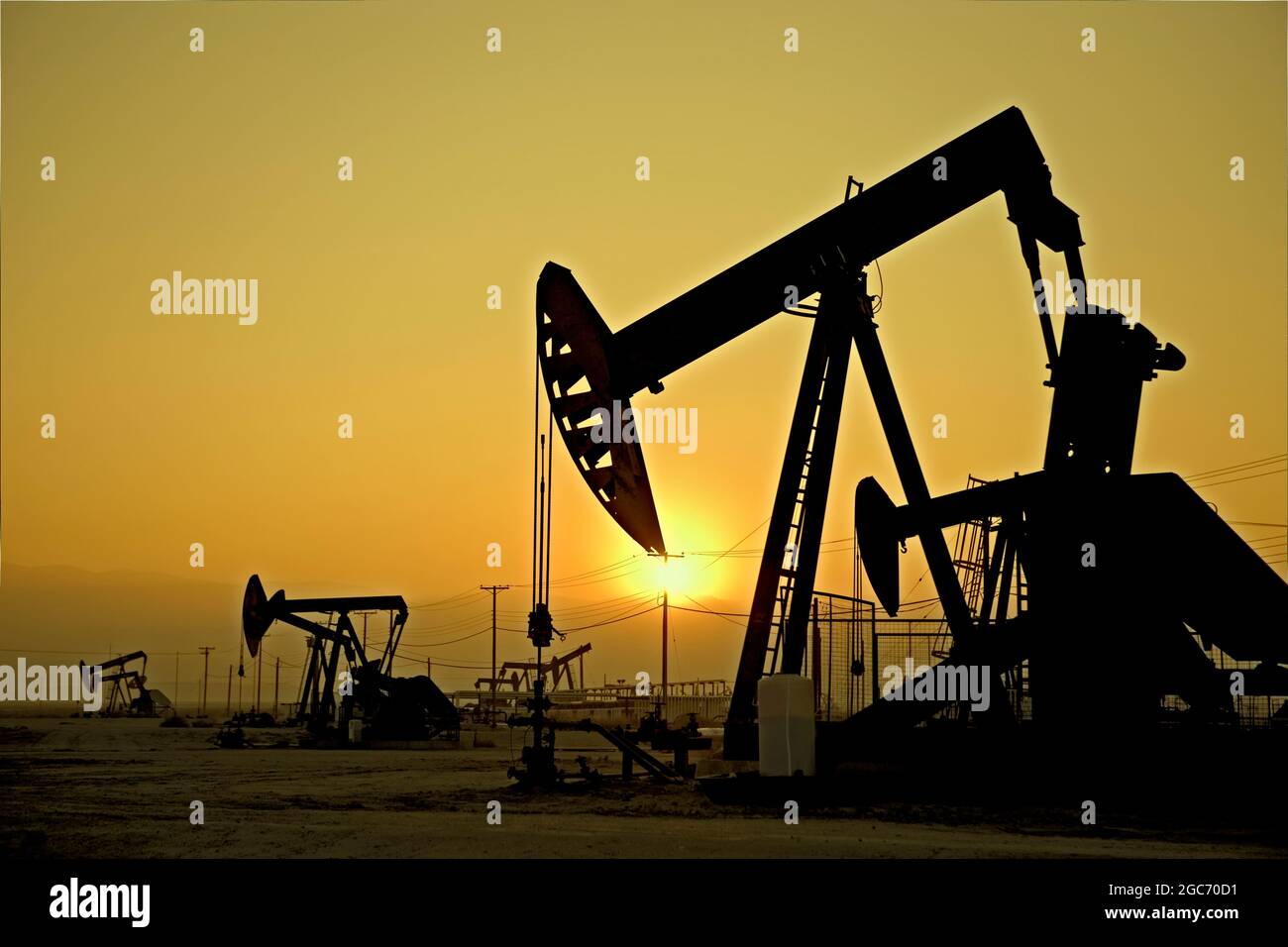 Silhouette of pump jacks in oil field at sunset Stock Photo Alamy