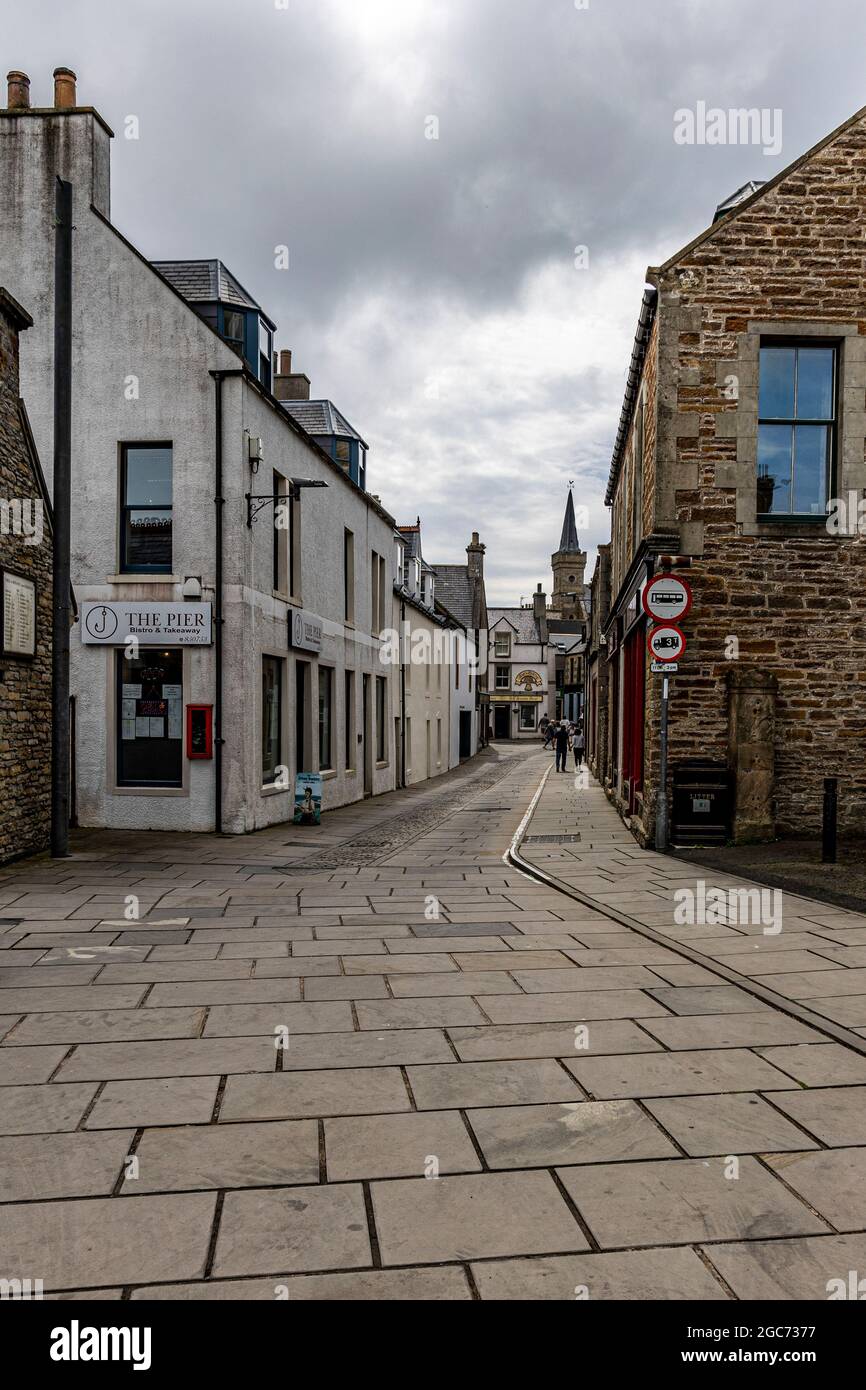 Narrow main street.  Stromness locally is the second-most populous town in Orkney, Scotland. It is in the southwestern part of Mainland Orkney. Stock Photo