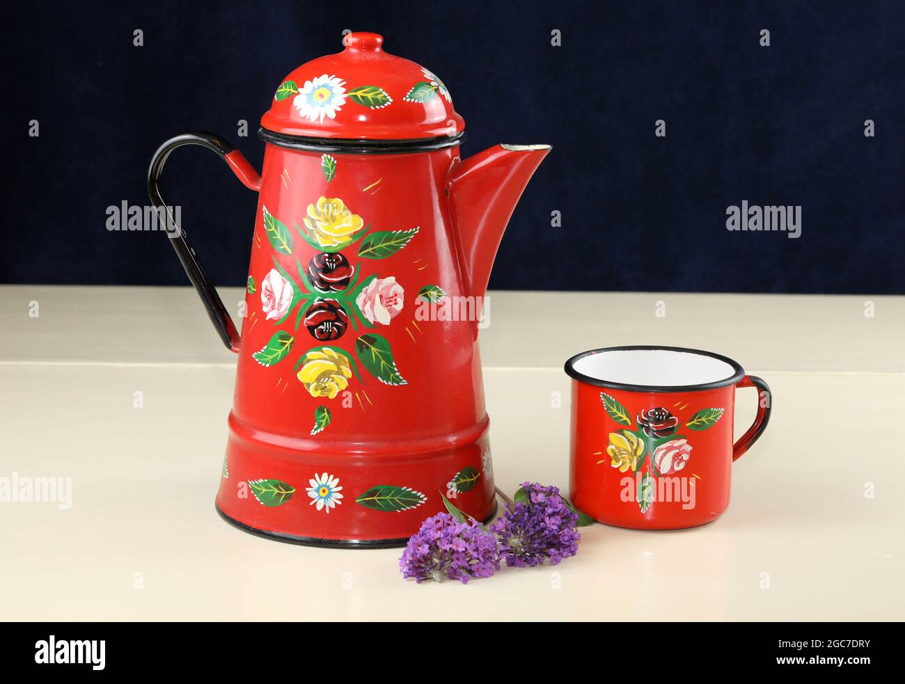 An Image Of A Red Enamel Coffee Pot Painted With Roses Stock Photo