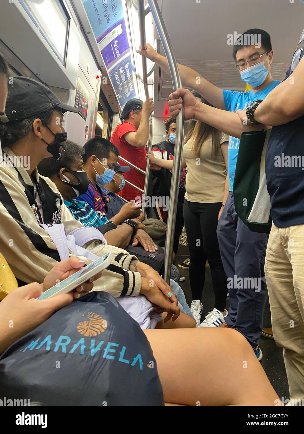 Everyone is masked up riding a New York City subway train during the ...