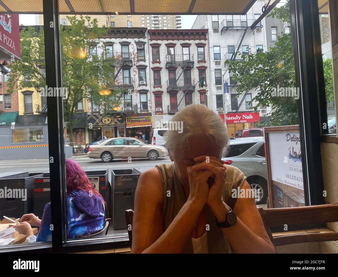 Woman in a moment of prayer before having lunch at an Upper East Side restaurant along 1st Avenue in Manhattan, New York City. Stock Photo