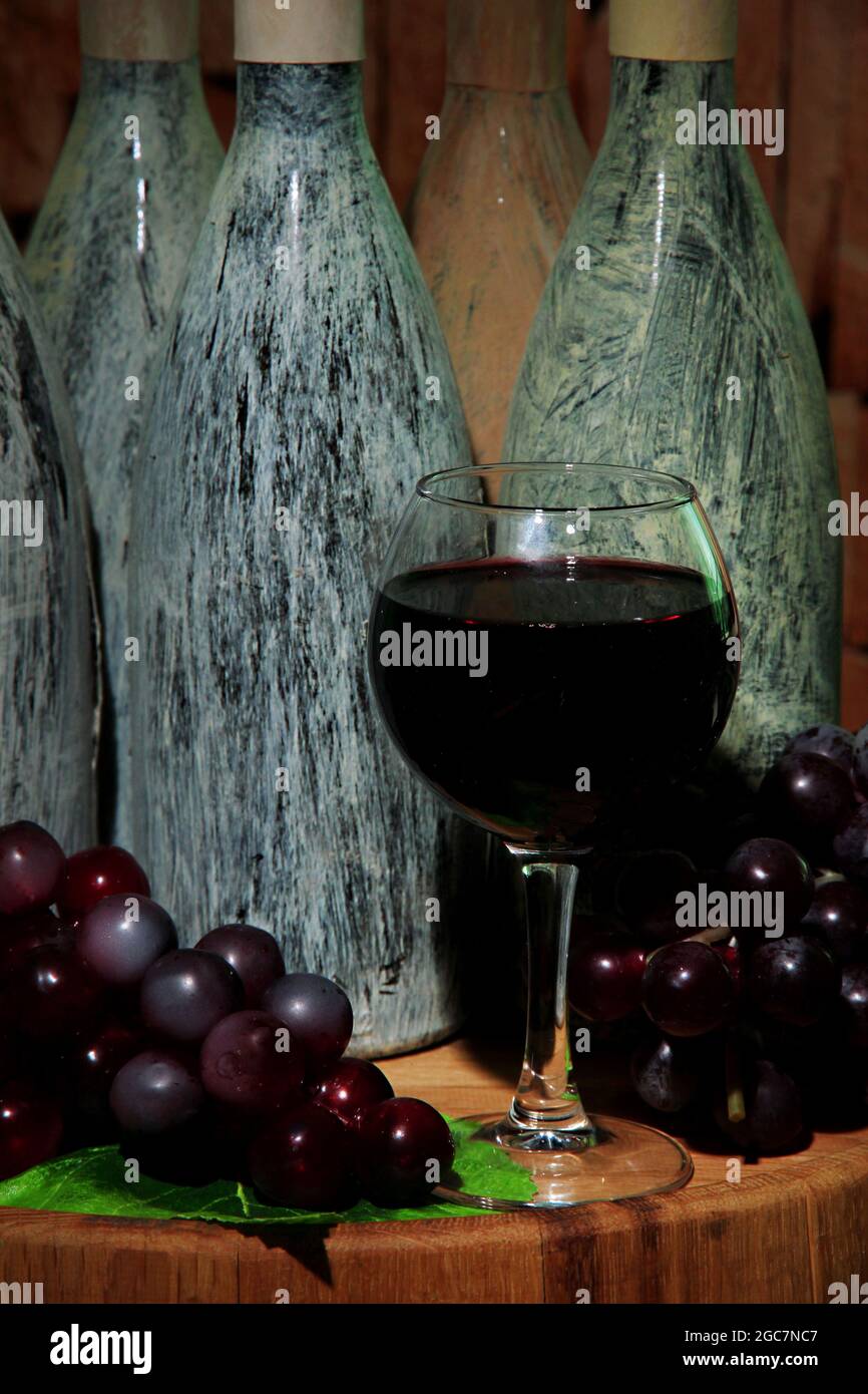 Composition with old bottles of wine and wineglass in old cellar, on
