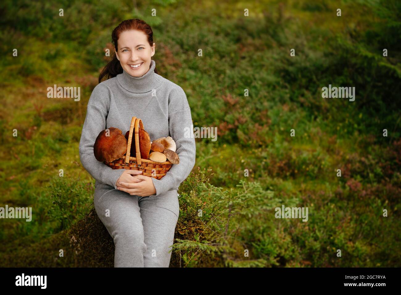 Forest mushrooms in a wicker basket collected by a mushroom picker Stock Photo