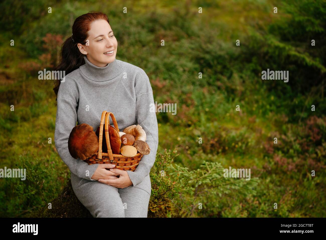 Woman is resting in a green forest with mushrooms Stock Photo