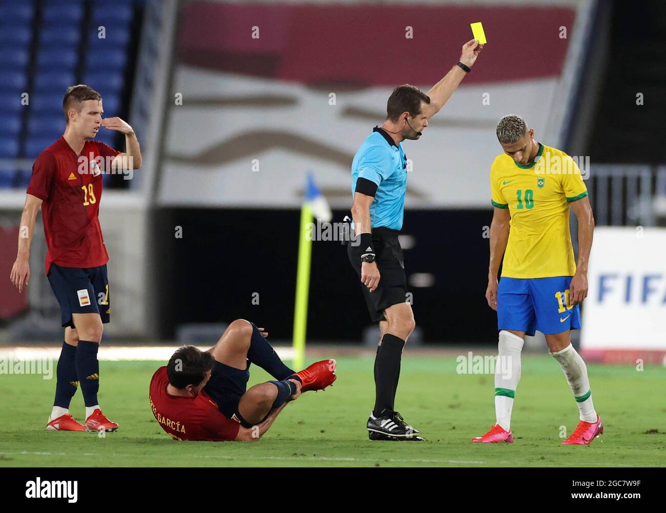 Yokohama, Japan. 7th Aug, 2021. Referee shows a yellow card to Richarlison of Brazil (1st R) during the men's football final between Brazil and Spain at the Tokyo 2020 Olympic Games in Yokohama, Japan, Aug. 7, 2021. Credit: Cao Can/Xinhua/Alamy Live News Stock Photo