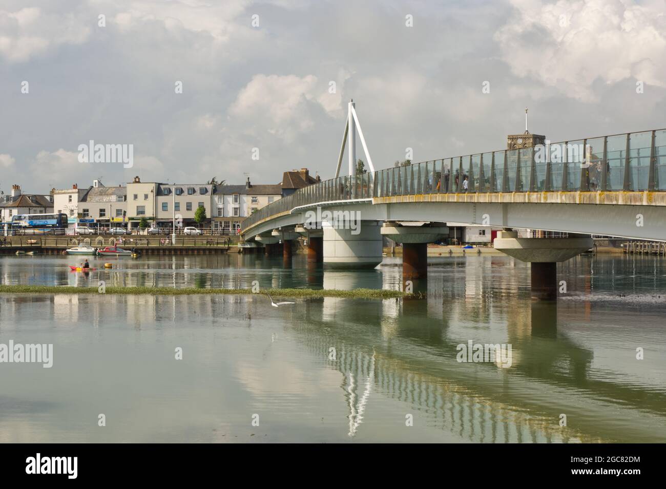 Footbridge over River Adur at Shoreham, West Sussex, England. With town behind and people walking around. Stock Photo