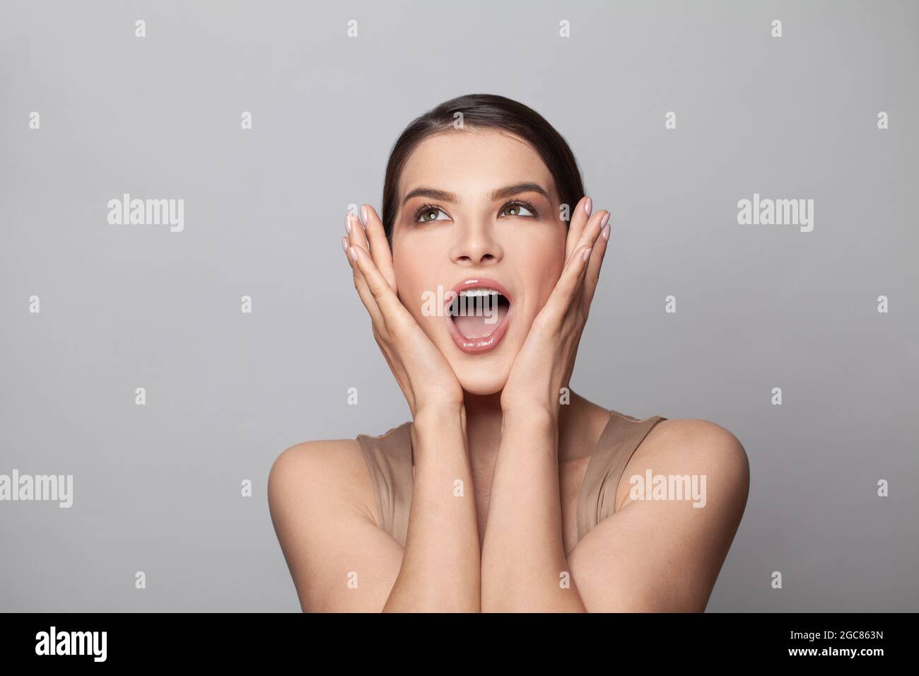 Shocked surprised woman with open mouth on white background Stock Photo