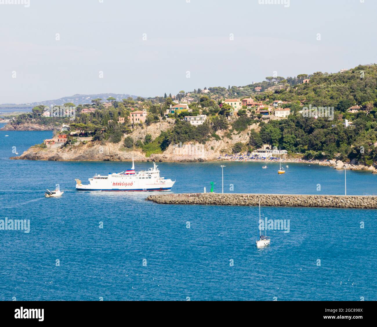 A ferry pulls into the ferry port of Porto Santo Stefano in Tuscany, Italy. Stock Photo