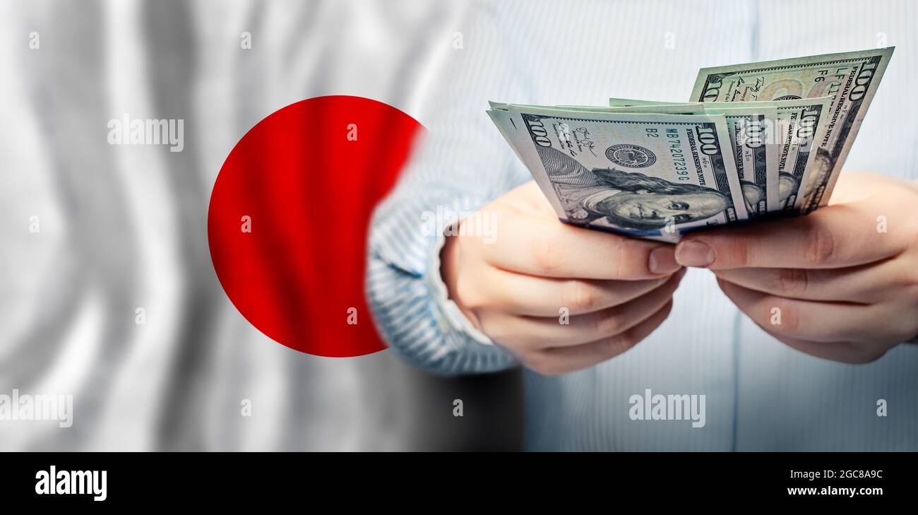 American dollars in hands on flag of Japan Stock Photo Alamy