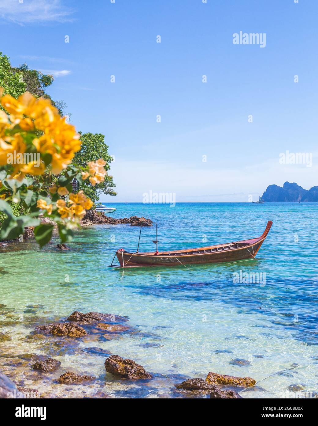 Long-tail boats, the Andaman Sea and hills in Ko Phi Phi Don, South Thailand. Clear blue water can be seen. There is space for text Stock Photo