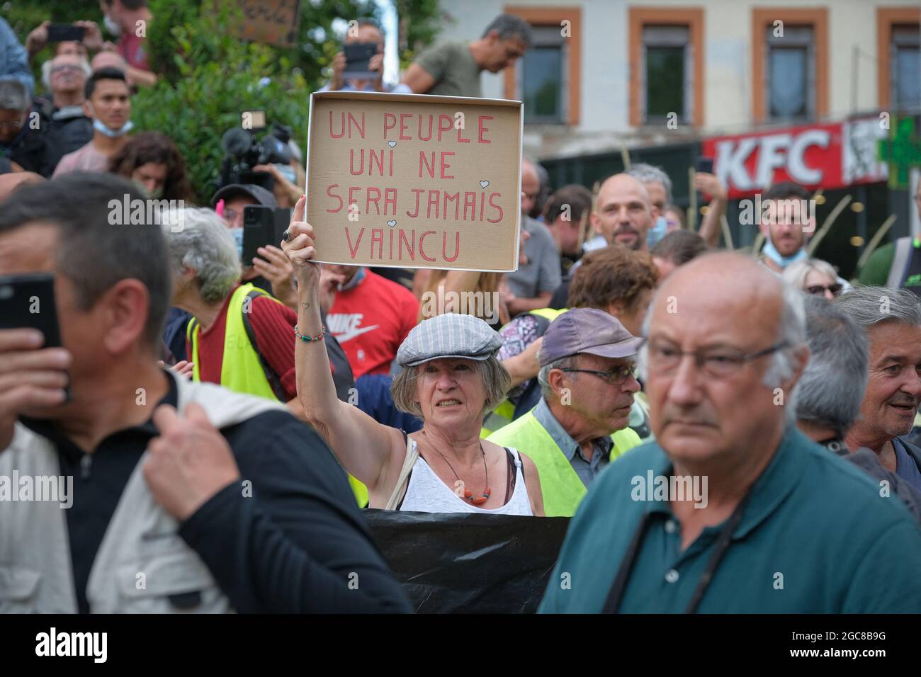 Protester with sign "A united people will never be defeated" (Un peuple uni ne sera jamais vaincu). On August 7, 2021, several thousand people defied the prefectural ban on demonstrating, marching in the streets of Toulouse (France). Chanting the word "Freedom", and anti-Macron slogans, the demonstrators marched on the boulevards of the city center, thus protesting against the Sanitary Pass. Photo by Patrick Batard/ABACAPRESS.COM Stock Photo