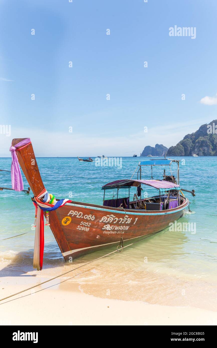 KO PHI PHI, THAILAND, 31ST MARCH 2017: A long-tail boats in Ko Phi Phi Don, South Thailand. Clear blue water can be seen. Stock Photo