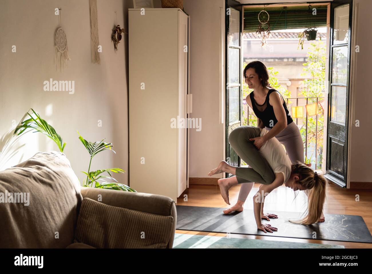 Young people doing yoga class indoors at home - Soft focus on top woman face Stock Photo