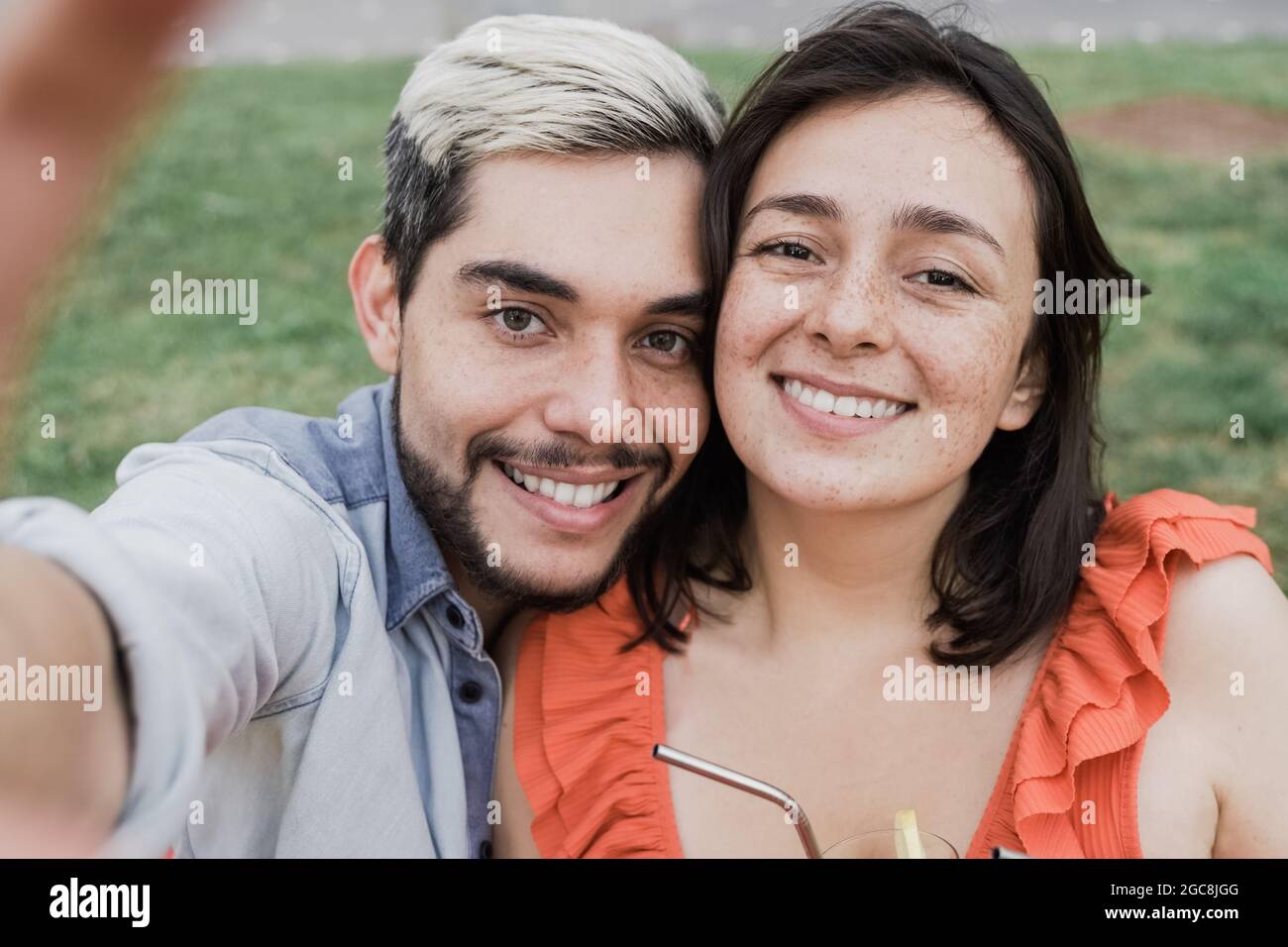 Young hipster couple taking selfie portrait with mobile phone outdoor in the city - Tourist friends and weekend holidays - Main focus on girl Stock Photo