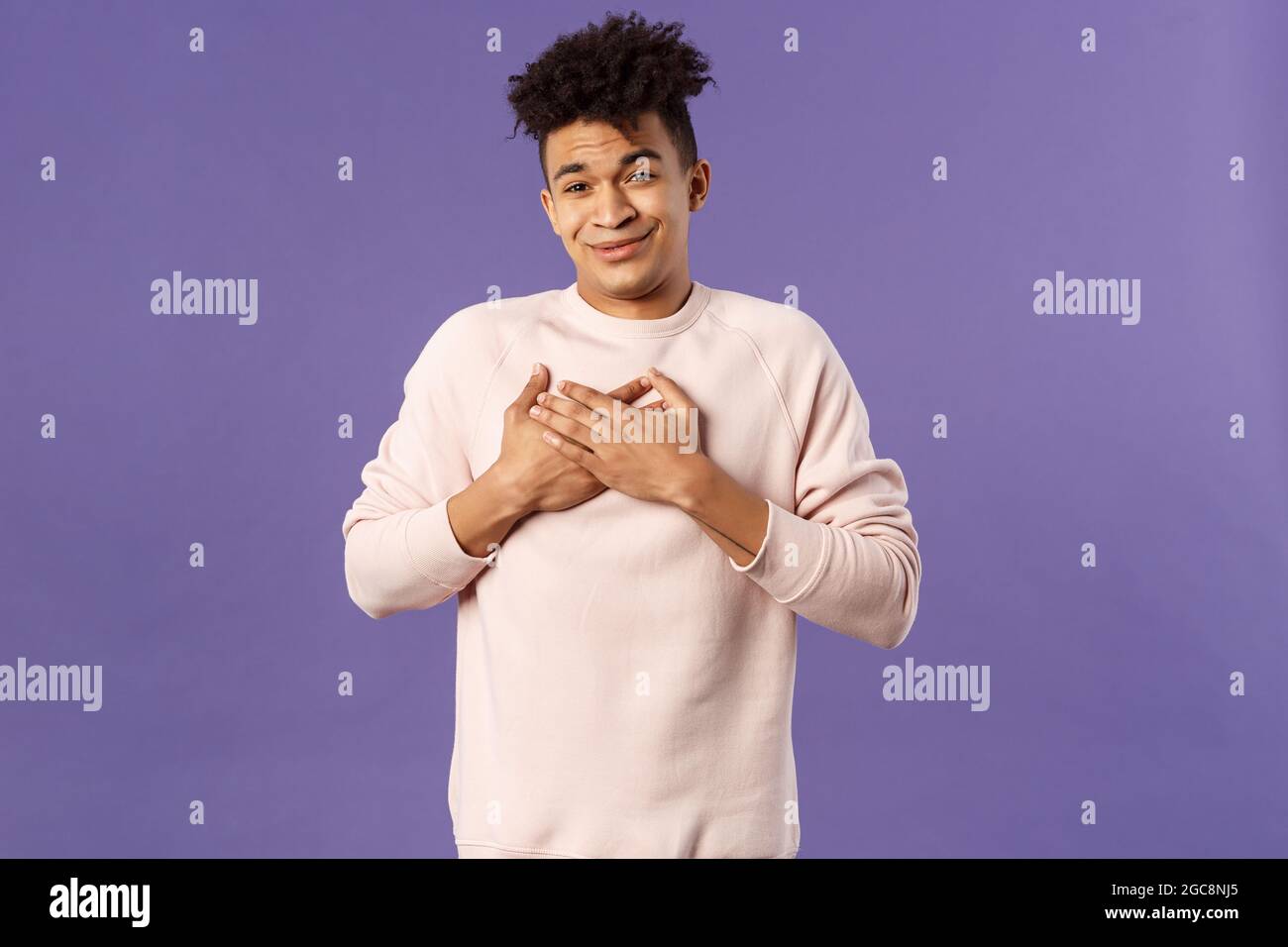 Portrait of touched silly young man left speechless and flattered, sobbing as being hit right into heart with dear warm words and praises, pleased Stock Photo