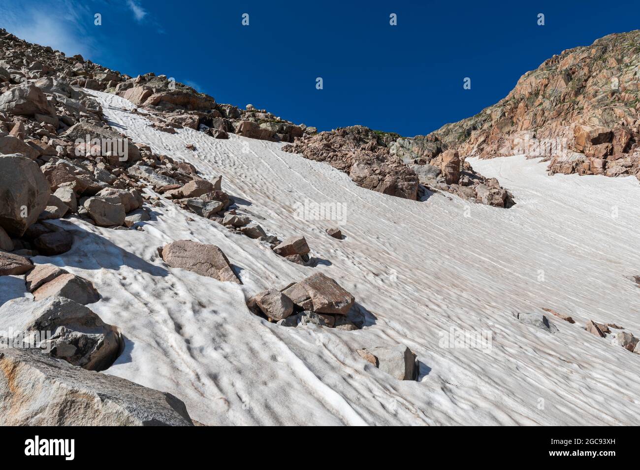 Large summer snowfield near Rowe's Glacier in Rocky Mountain National Park Stock Photo