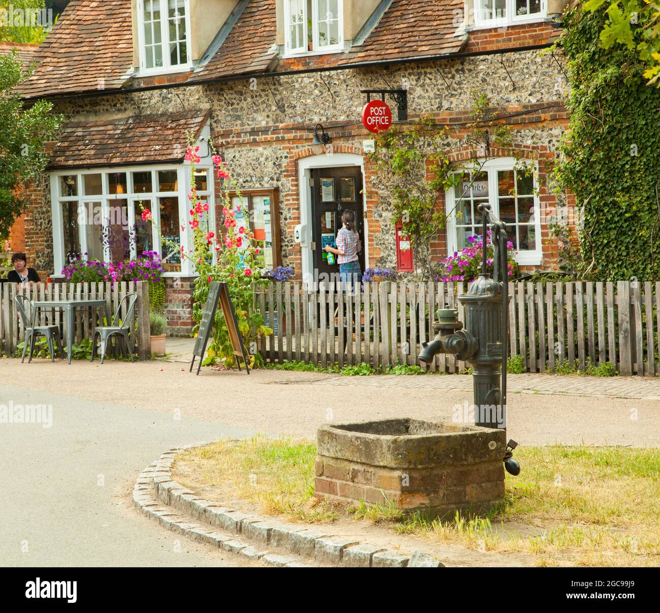 The village post office shop and café at the picturesque Chilterns Buckinghamshire village of Hambleden  with its village green and water pump Stock Photo