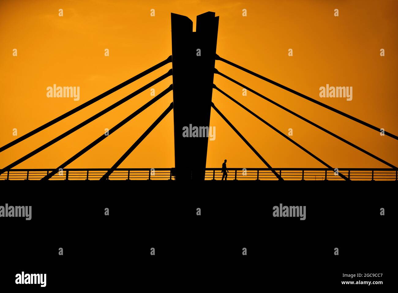 Silhouette of a man crossing a bridge Stock Photo - Alamy