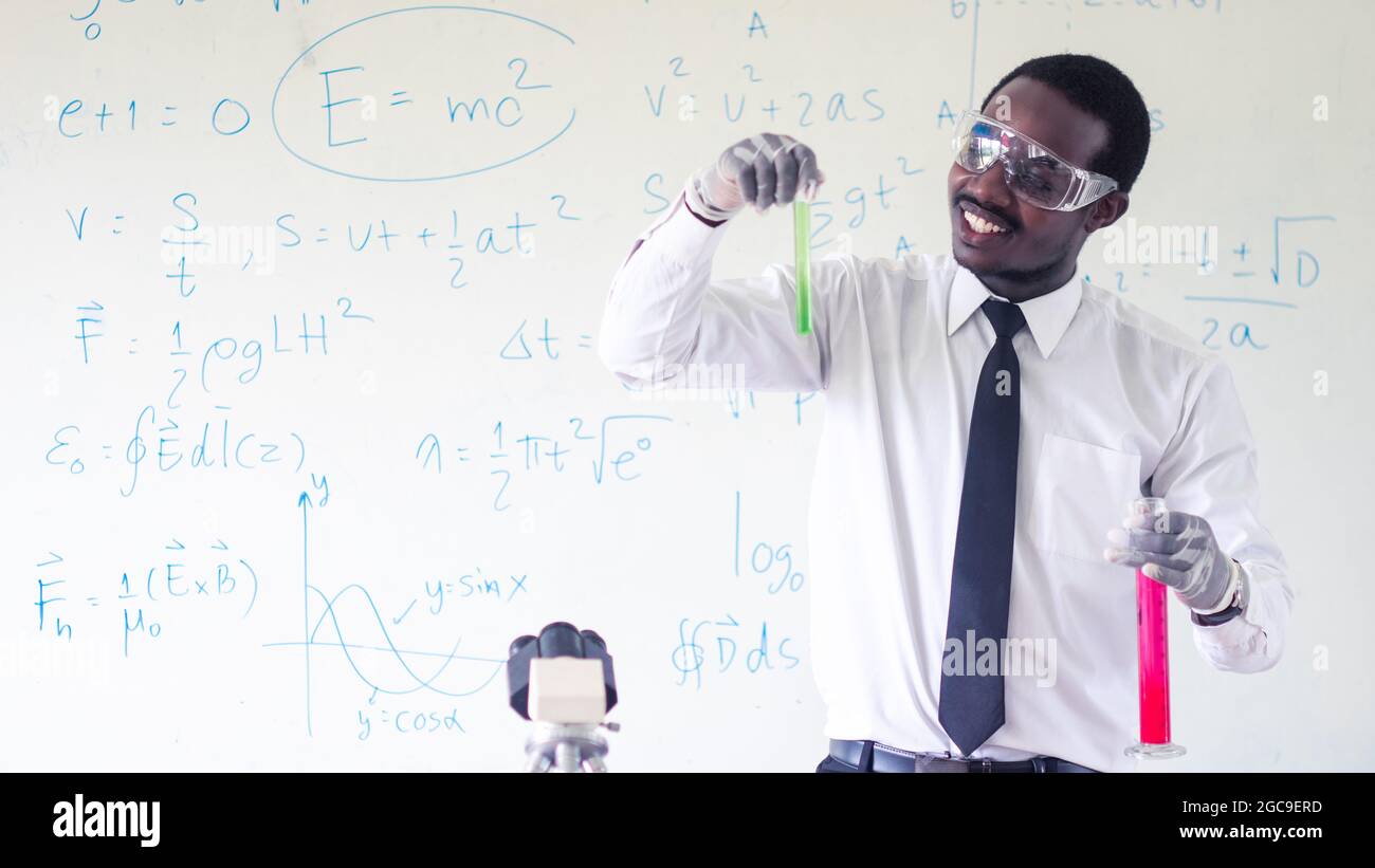 African Science Class African scientist teacher is holding and look at test tube with ...