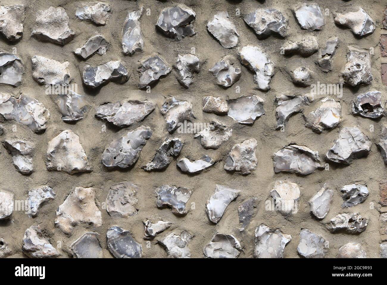 Flint wall background showing rough grey stones embedded in concrete Stock Photo