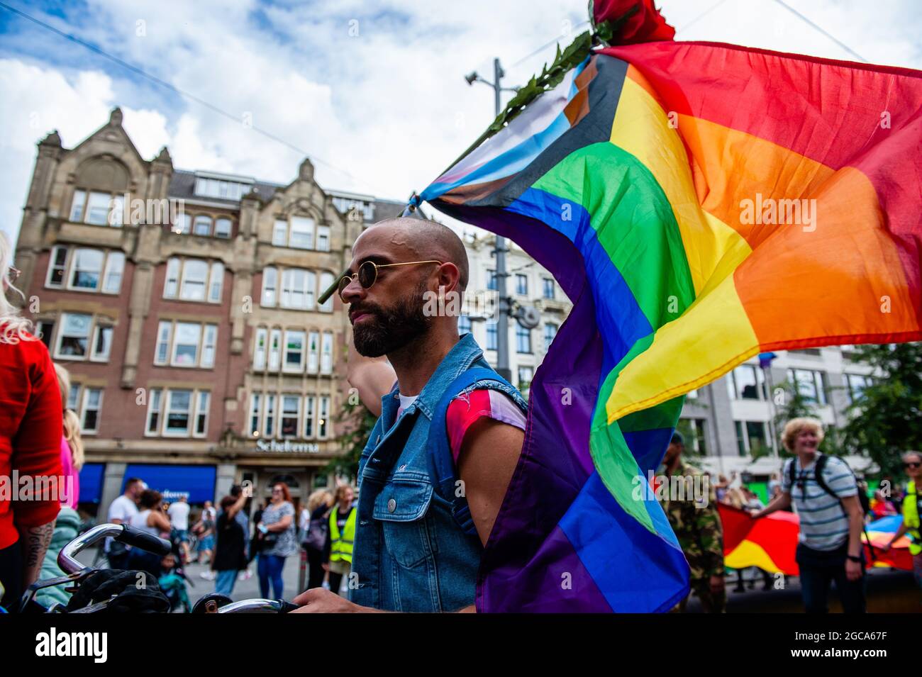 Amsterdam, Netherlands. 07th Aug, 2021. A protester holds a rainbow flag  with a rose during the demonstration.The annual equal rights demonstration  for the global rainbow community took place in Amsterdam. Due to