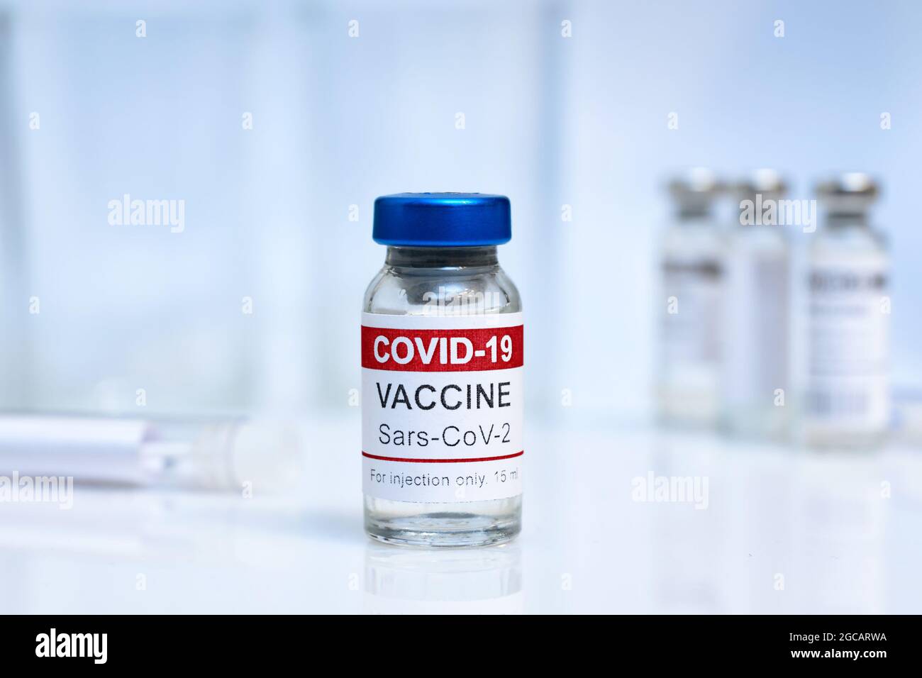 Corona virus vaccine on white lab desk, vial with COVID-19 vaccine on blurred background in laboratory. Concept of vaccination, reopening, science and Stock Photo