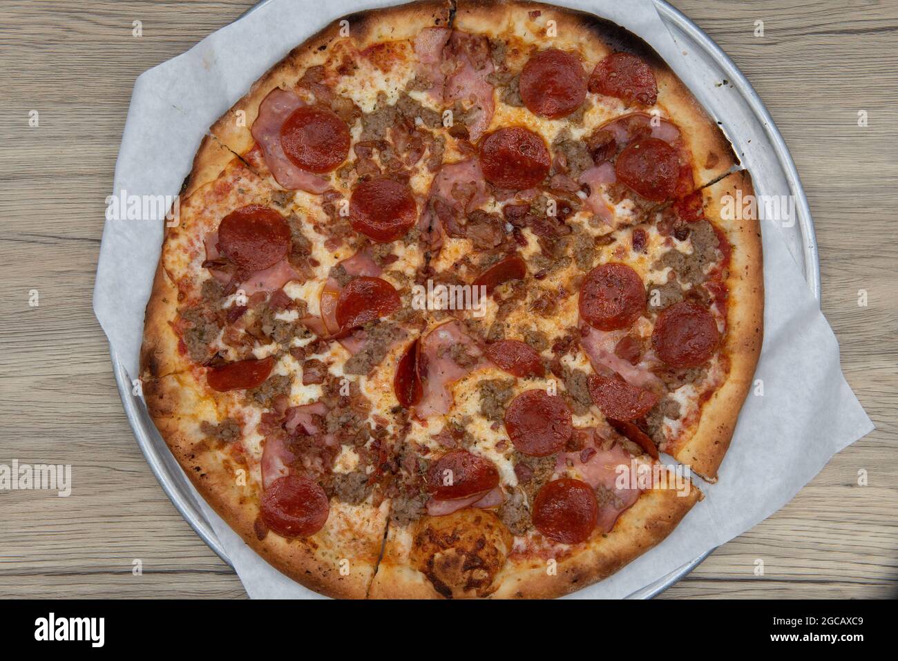 Overhead view of meat lovers pizza loaded with pepperoni, sausage