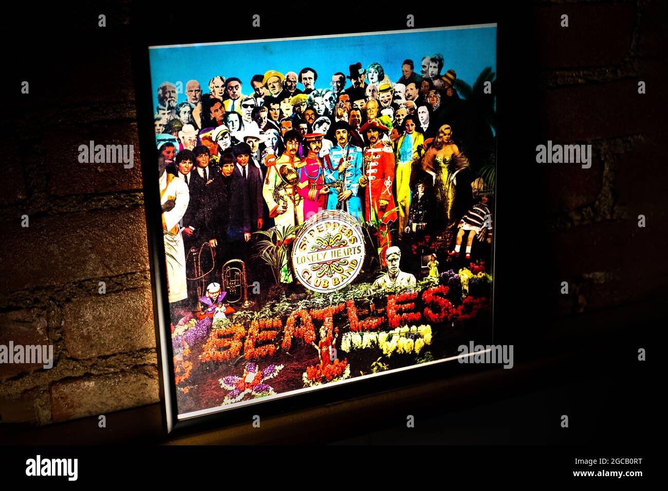 Closeup of The Beatles Sgt. Pepper's Lonely Hearts Club Band Vinyl Record Cover Leaning Against Brick Wall Stock Photo
