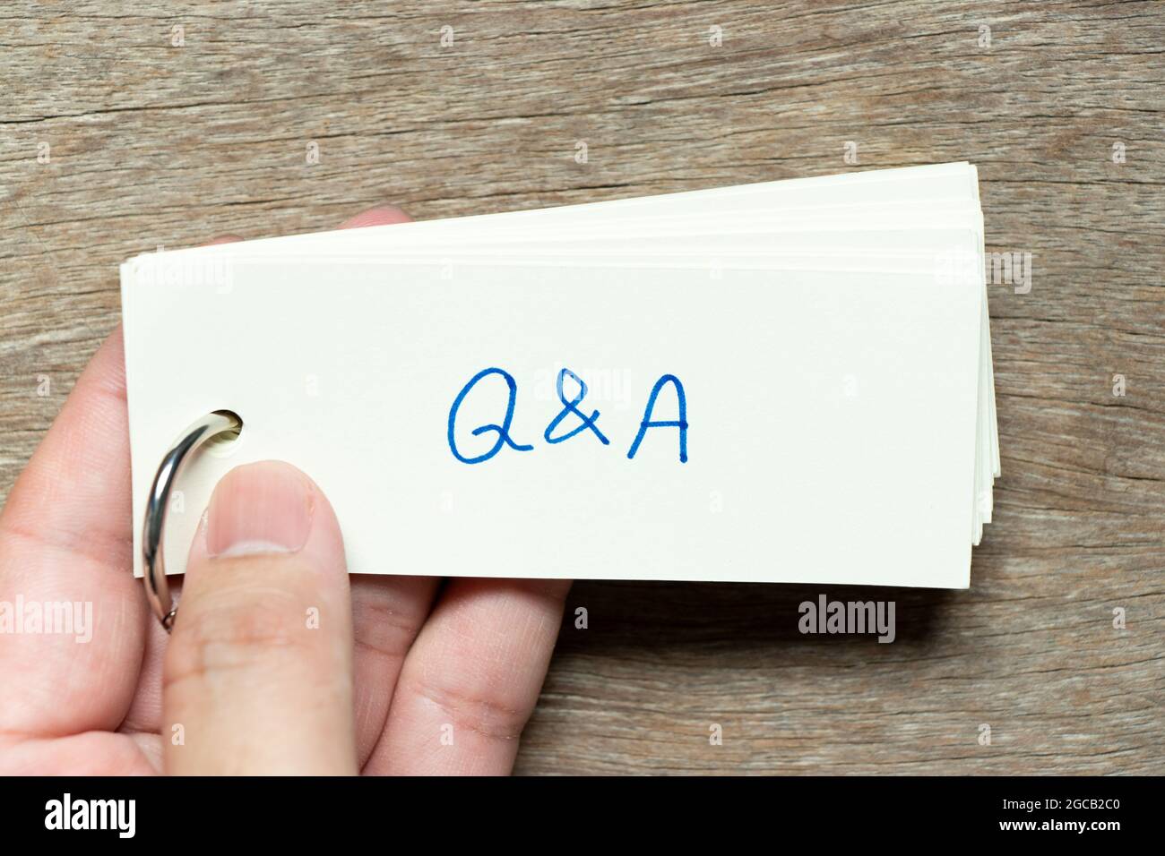 Man hold the flash card with handwriting word Q&A on wood background ...