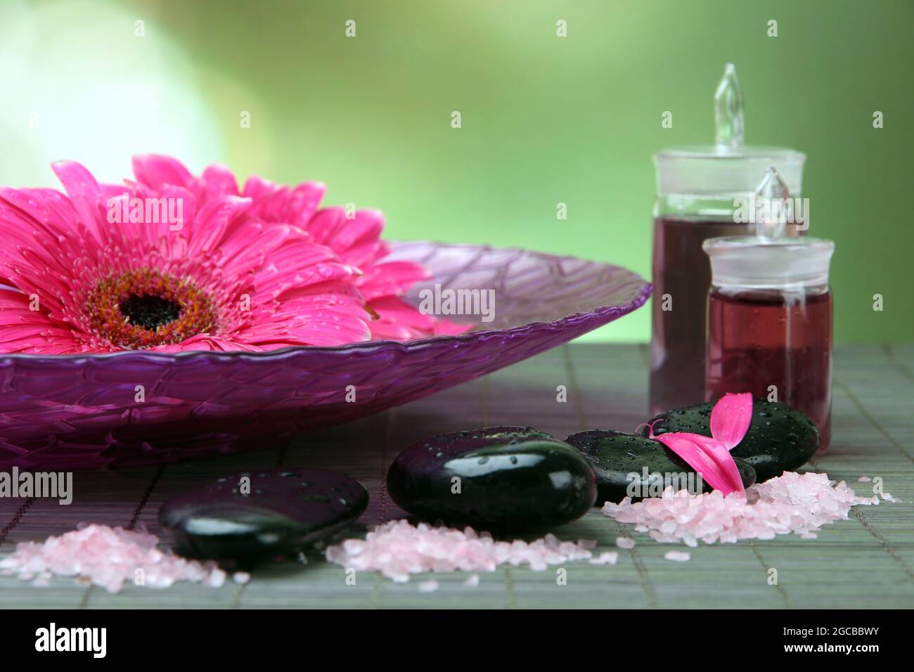 Gerbera flowers on water and spa stones on bamboo mat Stock Photo - Alamy