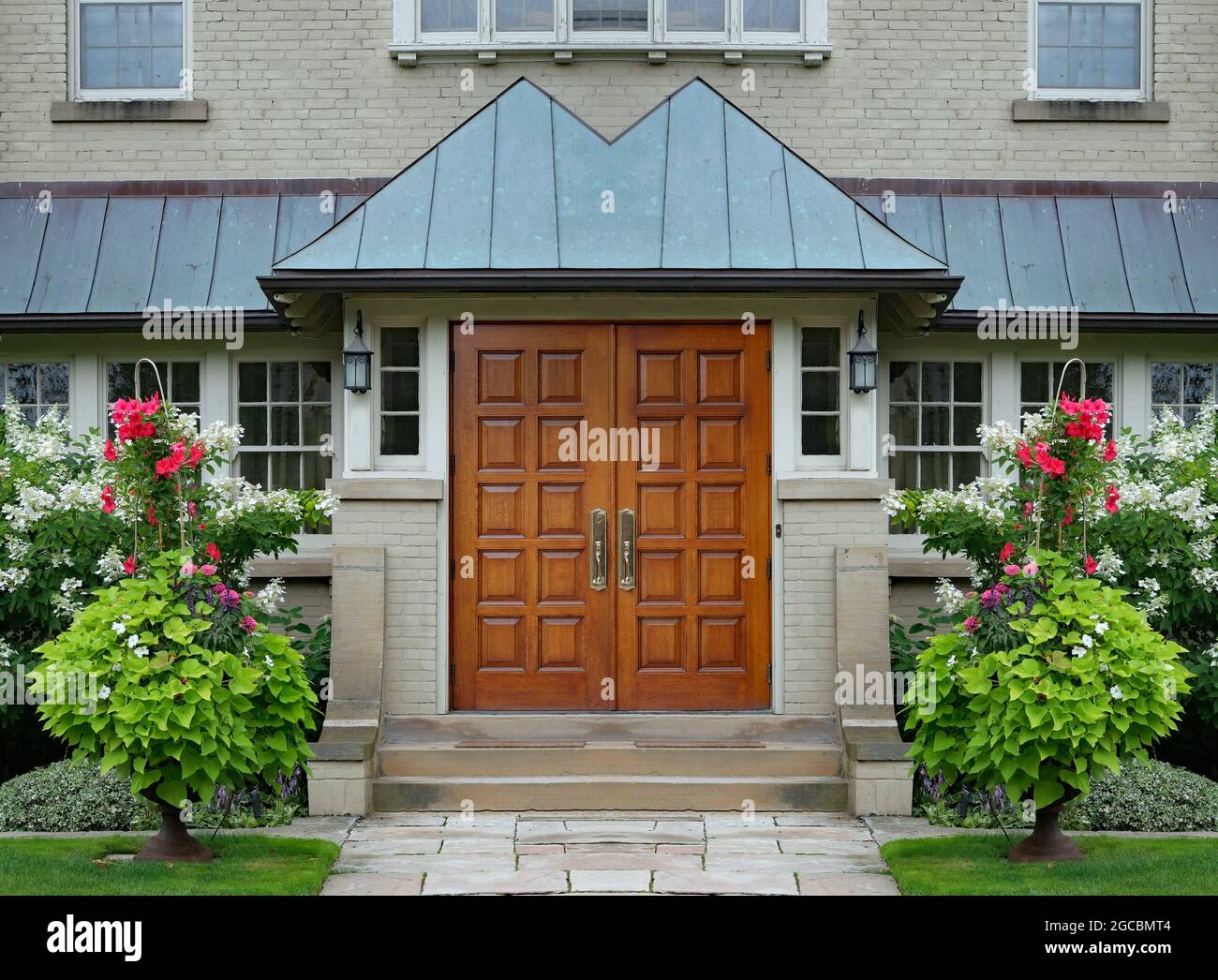 Elegant double wood grain front door with bright summer flowers Stock Photo Alamy