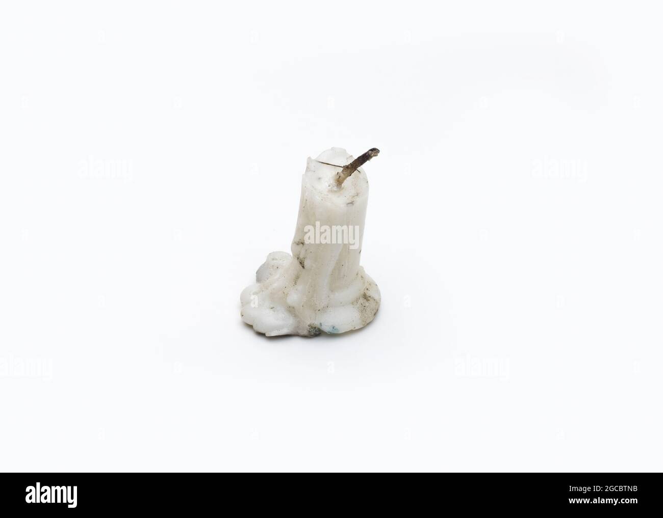 Old burnt out a dusty candle on isolated white background Stock Photo