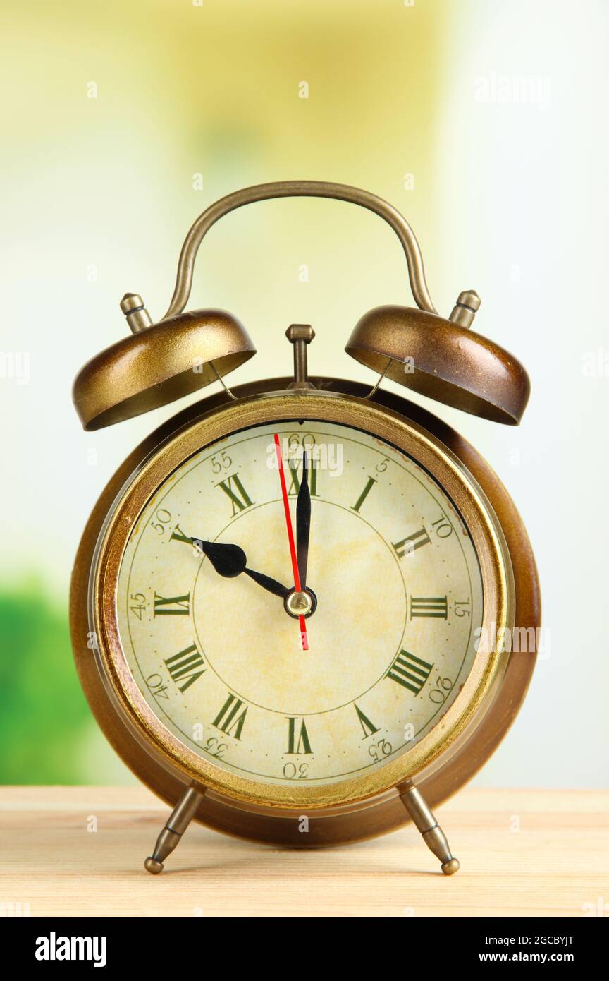 Old alarm clock on bright background Stock Photo - Alamy