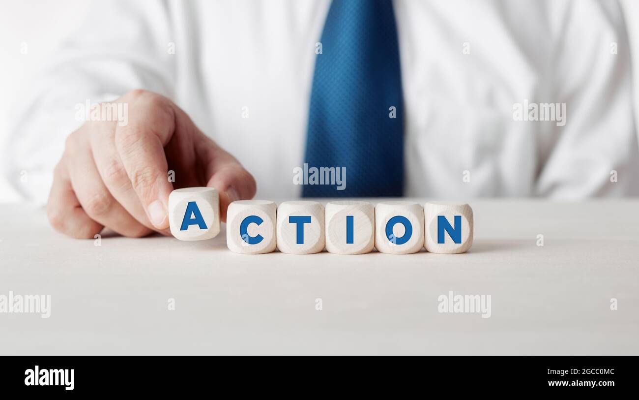 Businessman pressing his finger on the wooden cubes with the word ...