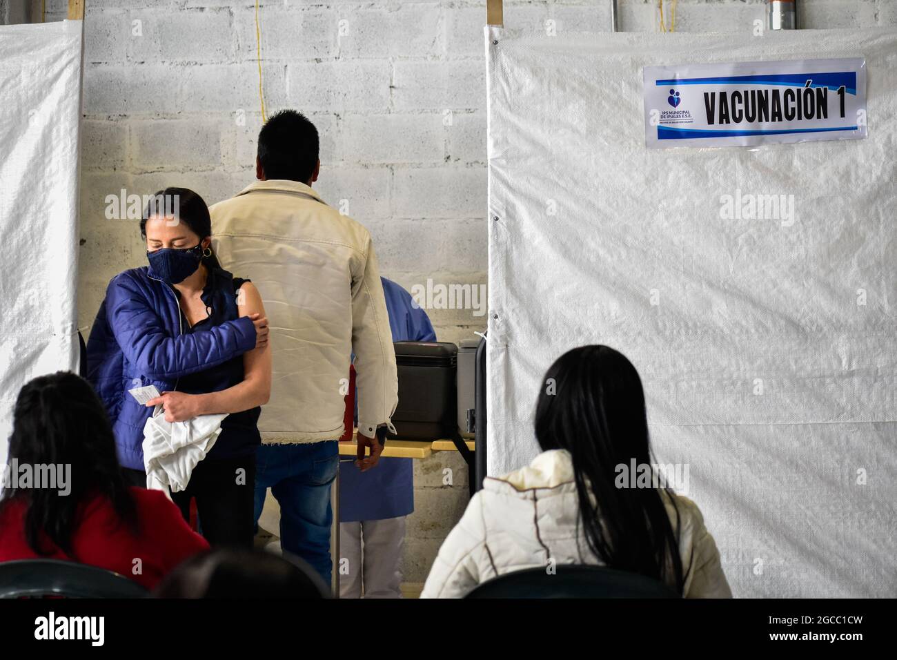 A women holds her hand against her arm after she got a dose of the Moderna COVID-19 vaccine as people from ages 25 to 30 start their vaccination phase with the Moderna novel COVID-19 vaccine against the Coronavirus disease in Ipiales - Nariño, Colombia on August 2, 2021. Stock Photo