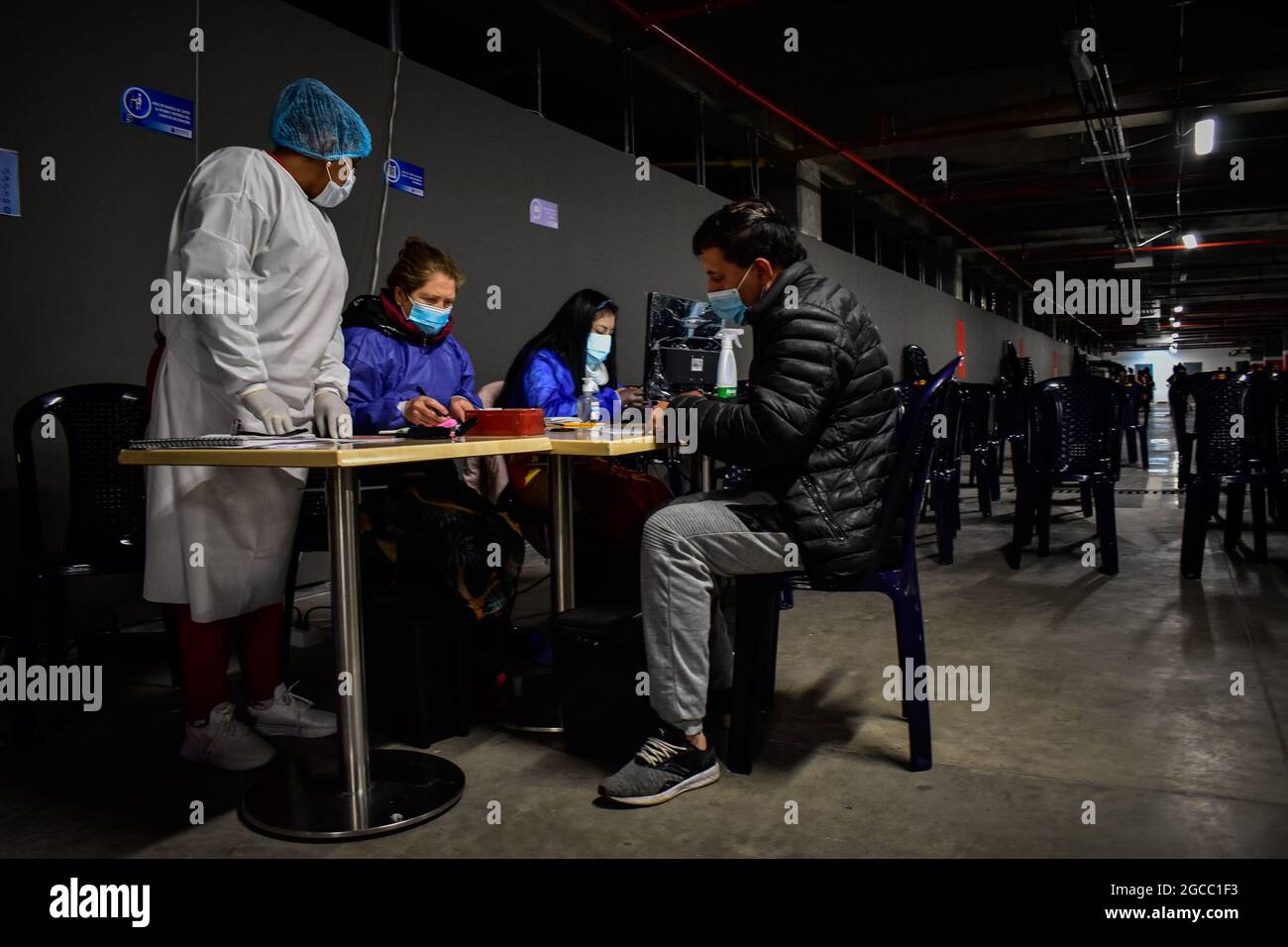 A men fills out the consents to get a dose of the Moderna COVID-19 as people from ages 25 to 30 start their vaccination phase with the Moderna novel COVID-19 vaccine against the Coronavirus disease in Ipiales - Nariño, Colombia on August 2, 2021. Stock Photo