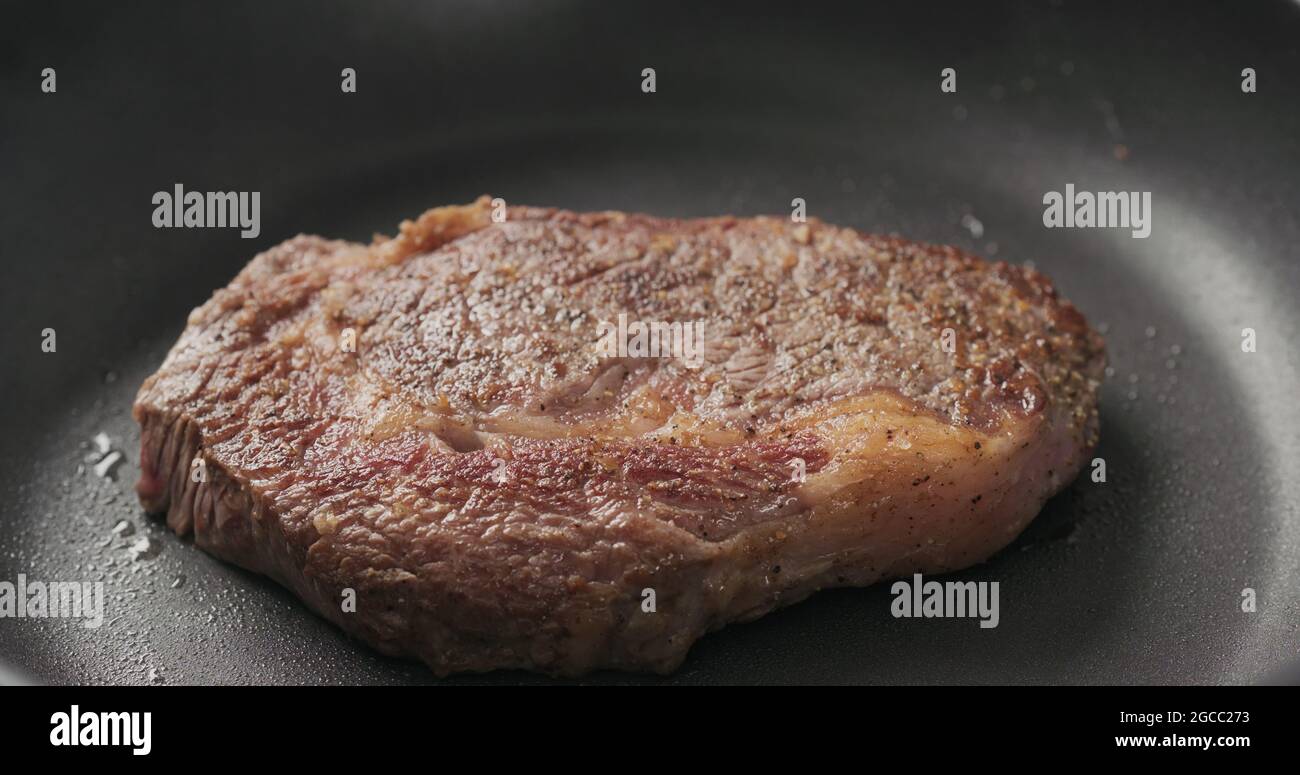 https://c8.alamy.com/comp/2GCC273/closeup-shot-of-ribeye-steak-frying-on-non-stick-pan-wide-photo-2GCC273.jpg