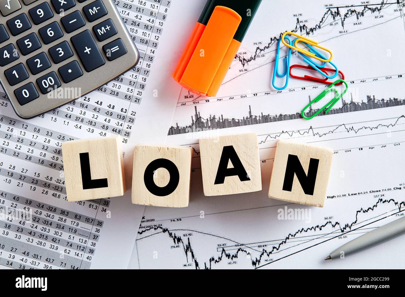 The word loan on wooden cubes with office desktop. Business and finance loan budget analysis concept. Stock Photo