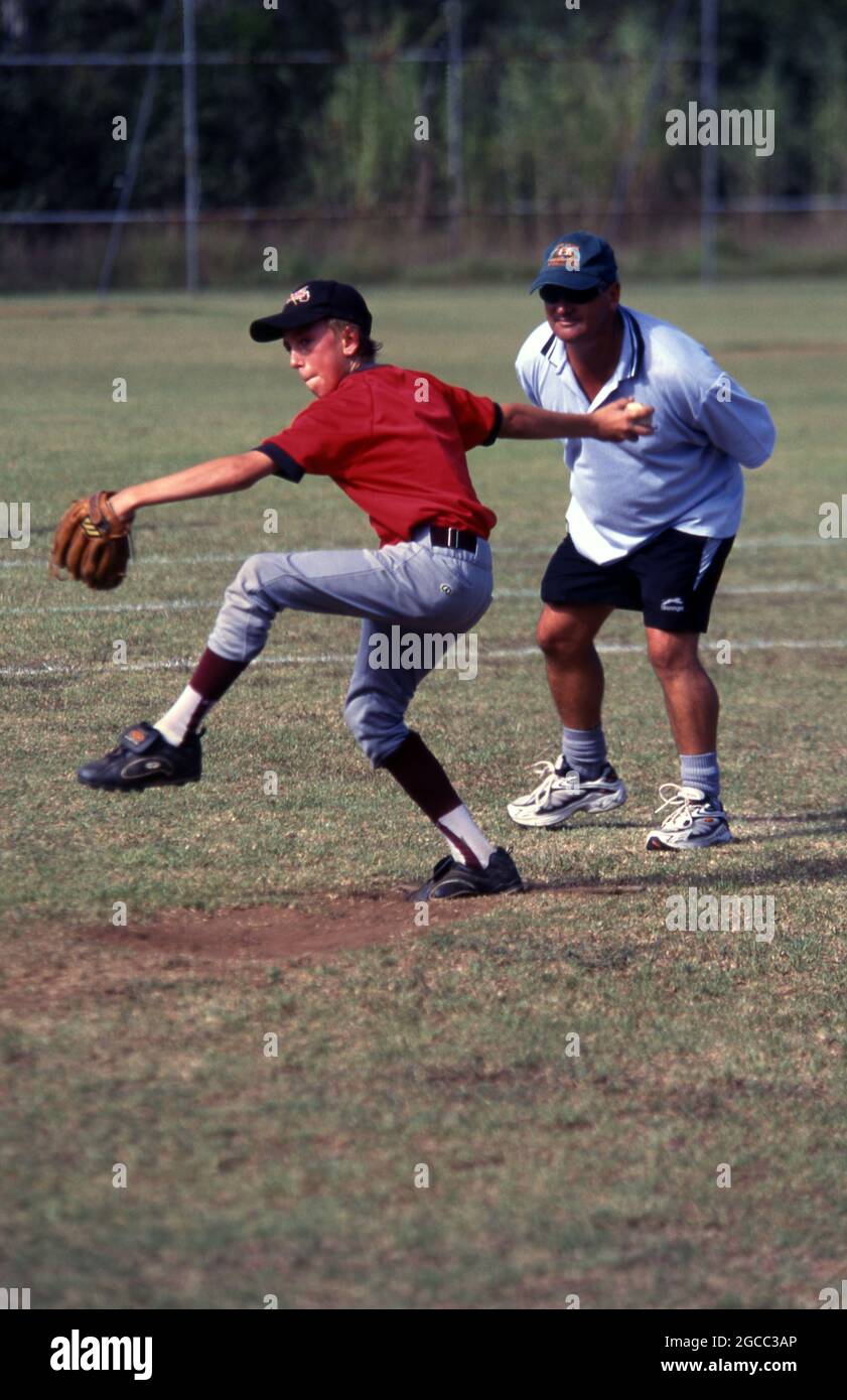 AN UMPIRE WATCHES CLOSELY AS A YOUNG PITCHER IS ABOUT TO PITCH THE BALL, JUNIOR BASEBALL GAME, NEW SOUTH WALES, AUSTRALIA. Stock Photo