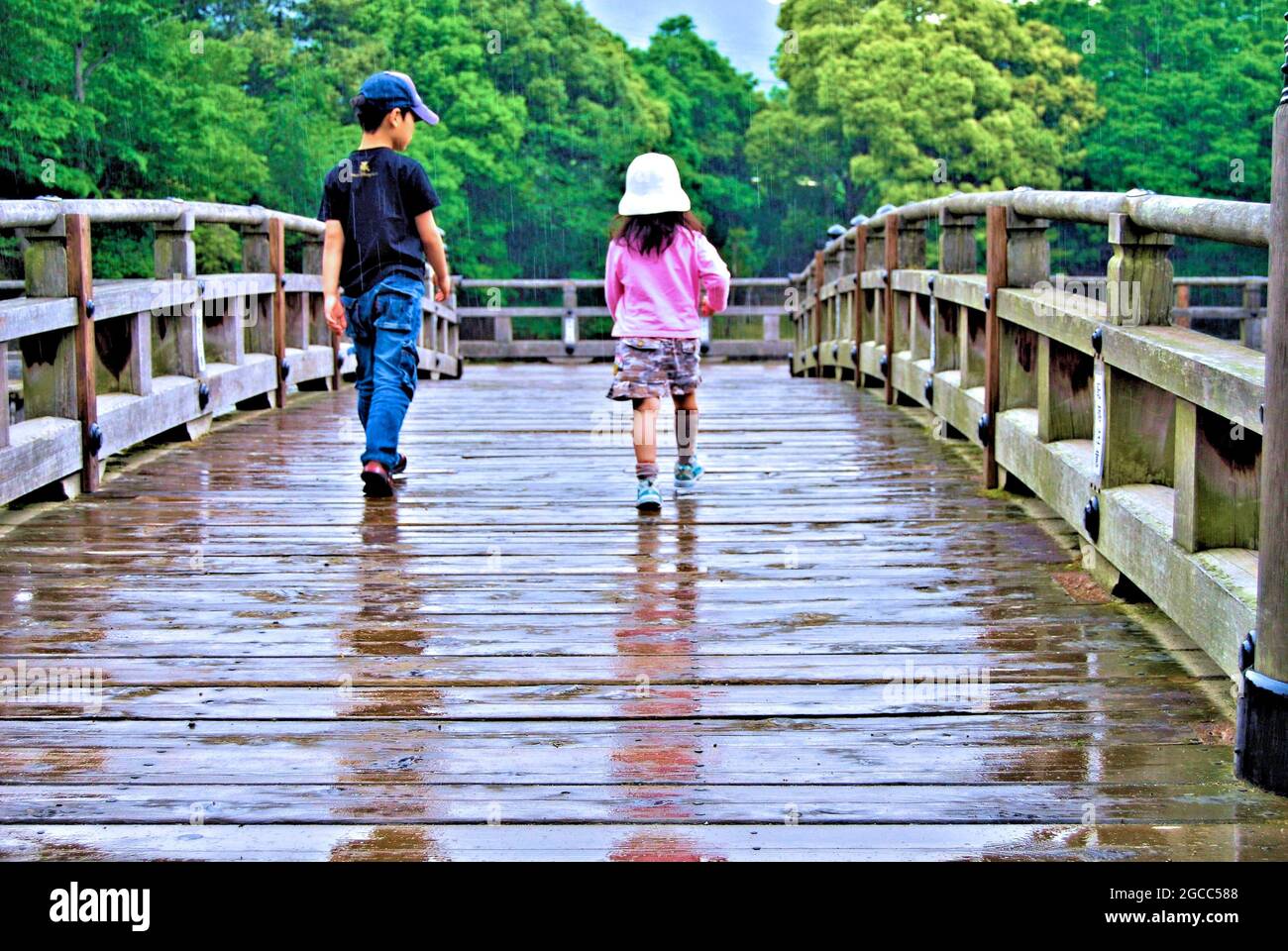 Children playing in the rain on the bridge to Ukimi-do Hall in Nara, Japan Stock Photo