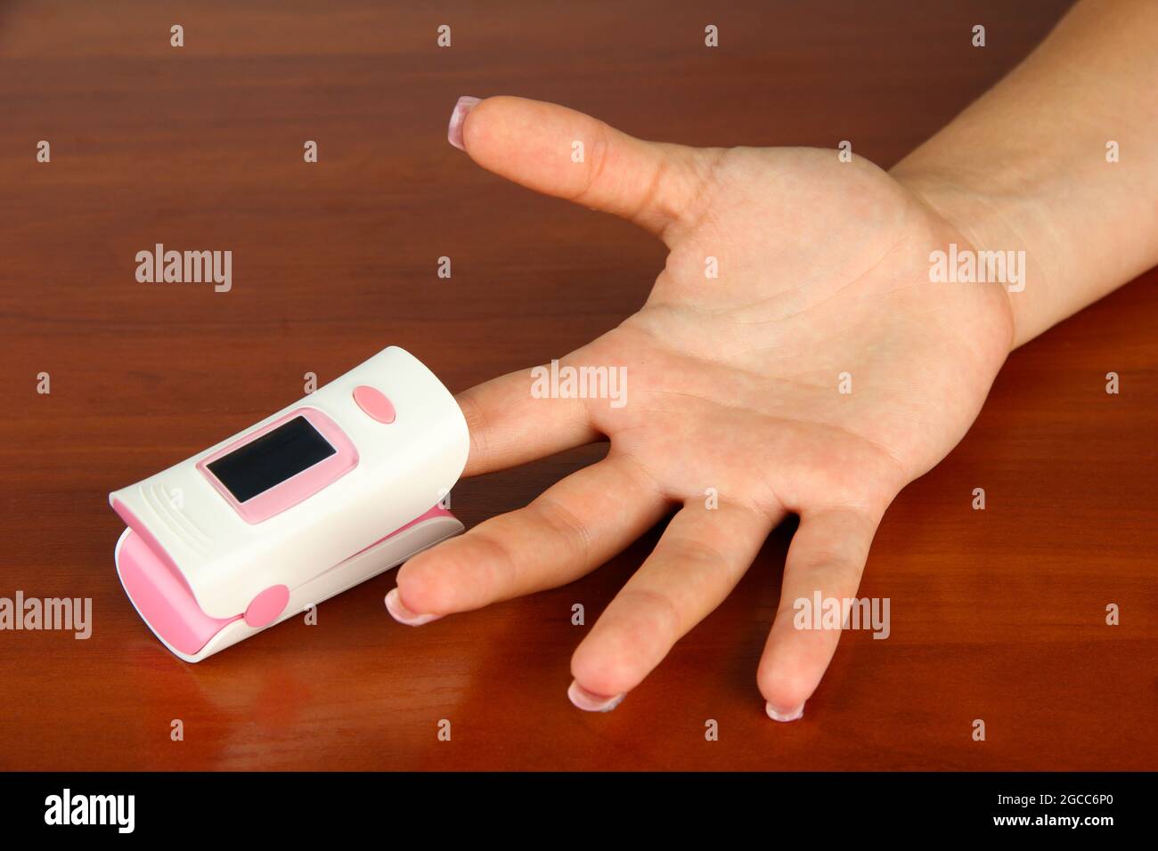 Pulse oximeter used to measure pulse rate and oxygen levels, on wooden