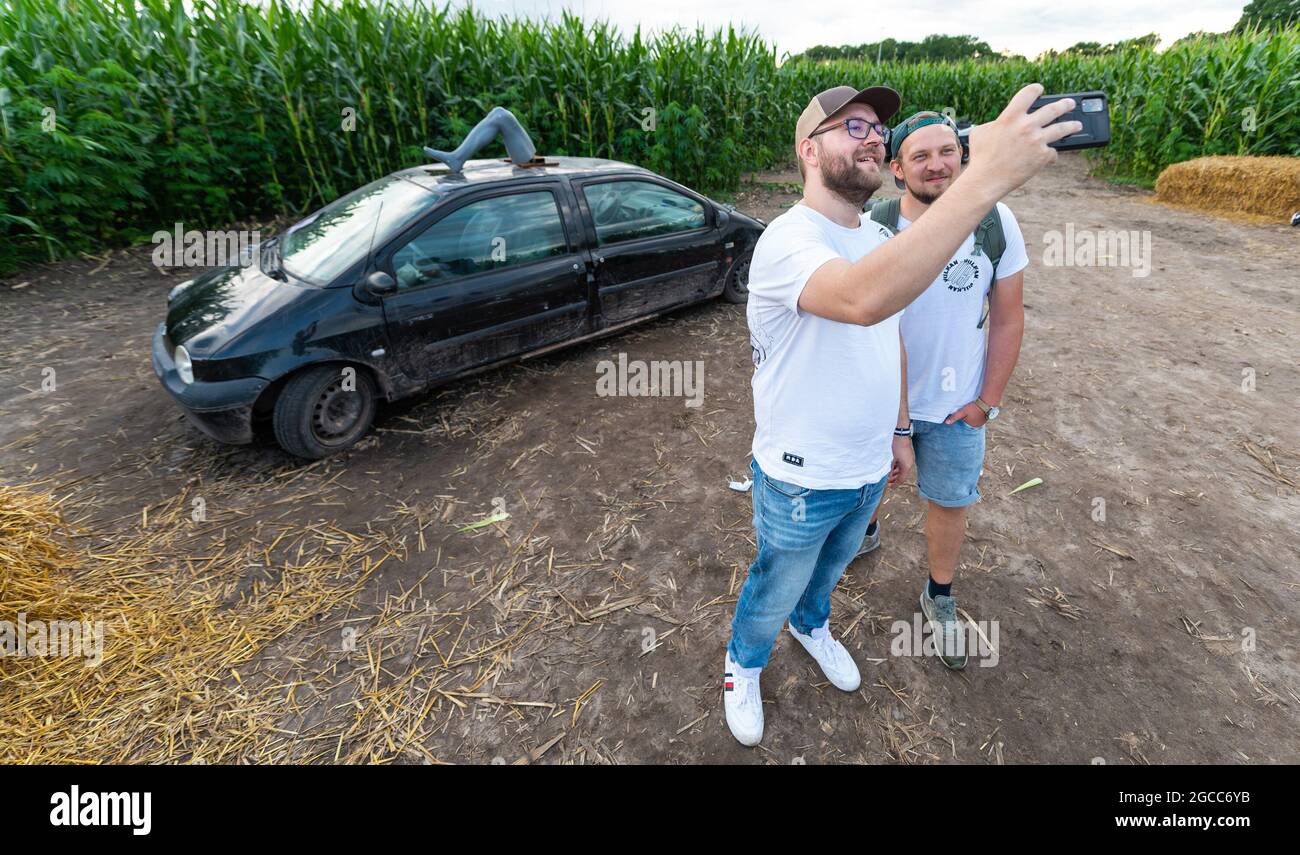 Elsdorf, Germany. 07th Aug, 2021. Tom (l) and Christian from Berlin take a picture of themselves at a station in the hemp-corn maze of 'Kliemannsland'. Youtuber and do-it-yourselfer Fynn Kliemann wants to 'lead you astray' with a hemp-corn maze near his creative farm 'Kliemannsland' in Elsdorf (Rotenburg/Wümme district). Credit: Philipp Schulze/dpa/Alamy Live News Stock Photo