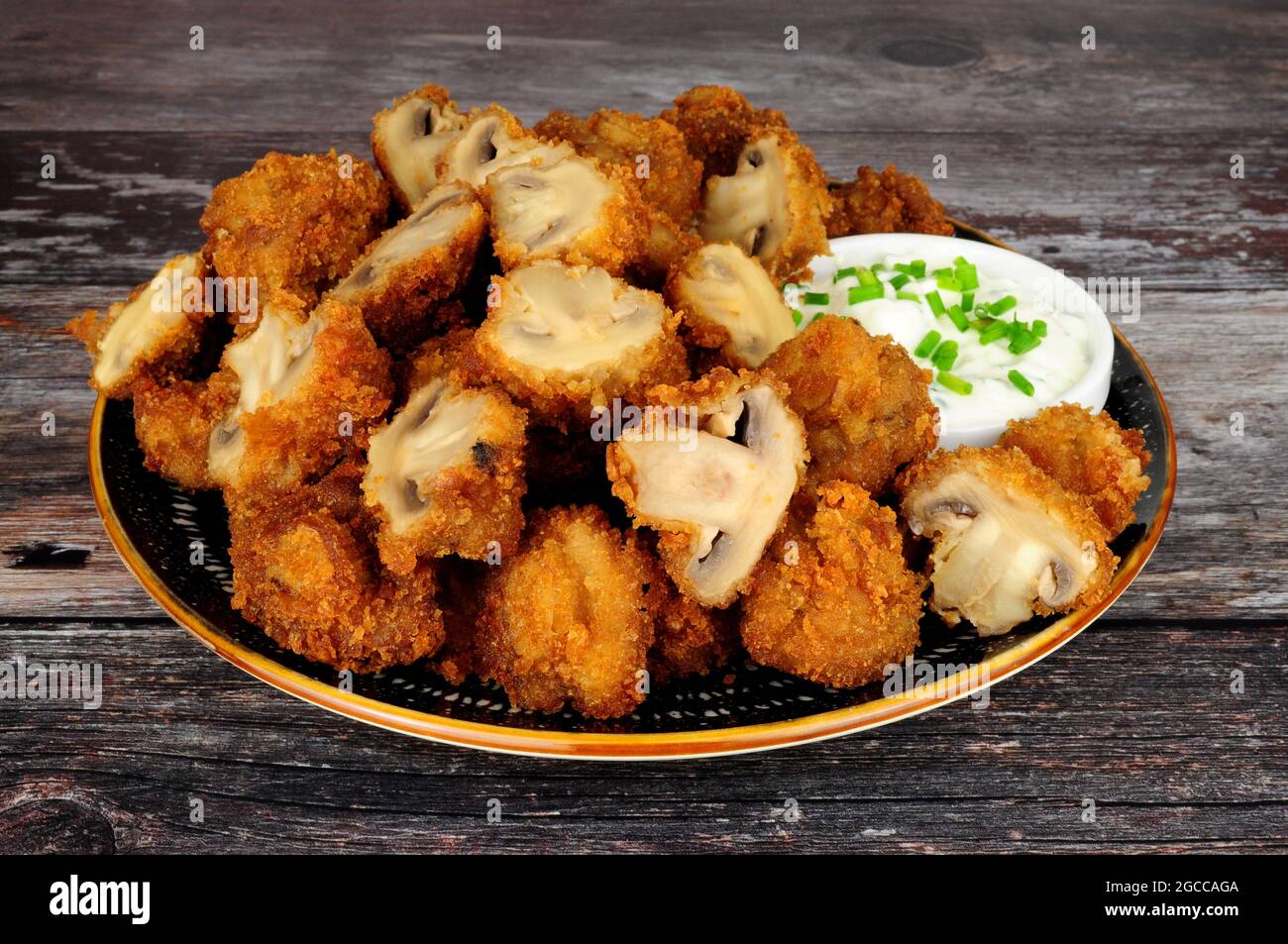 Whole breaded button mushrooms with soured cream and chive dip Stock